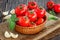 Cherry tomatoes, garlic and basil over wooden table backgroun