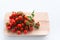 Cherry tomatoes lie on a butcher on a white background