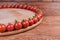 Cherry tomatoes on perimeter of wooden serving board, fragment