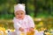 Cherubic baby girl playing with yellow leaves.