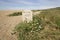 Chesil beach and distance marker on the South West Coast Path, Dorset England