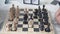 Chess board with figures. The man`s hand moves the chess piece