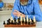 Chess figures on wooden board. Focused school teacher. thinking of attacking and capturing opponent chess pieces