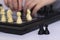 Chess game in action. Board in details. Close up of a child`s hand playing chess, a photo