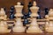 Chess game, close up of a black pawn, white figures in the front