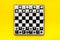 Chess game concept. Chess board with figures on yellow background top view copy space