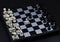 Chess game opening on chessboard. Checked board with figure on black background. Chess figurine order