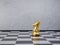 Chess gold knight with a crown on board. Selective focus