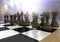 Chess pieces against blurry background with flares