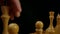 Chess player makes rocking with white wooden chess pieces