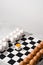 Chessboard with figures of white and brown eggs on a gray background. Creative Idea Easter and chess