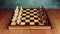 A chessboard made of wood with chess pieces placed on it stands on a table