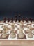 Chessboard with wooden figures placed opposite each other.