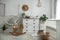 Chest of drawers with changing tray and pad near cradle in baby room. Interior design