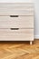 Chest of drawers with finger pull sliders on parquet floor