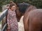 Chestnut andalusian horse leaning with complicity on a female.