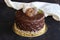 Chestnut, chocolate and pistachio cake on a dark wooden background.