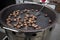 Chestnuts roasted in a large pan for sale on the street