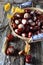 Chestnuts in wicker basket and autumn leaves