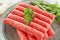 Chevapchichi is a national Balkan dish. Close up a row of fresh raw beef kebabs on a plate