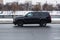 Chevrolet Tahoe car drive on Moscow streets. Black GMC Yukon speeding on winter street. Fast moving SUV on the wet road, side view