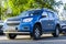 Chevrolet Trailblazer Second generation front-side view. Blue crossover SUV standing on the background of green tree