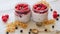 Chia milk pudding with fresh raspberry in the glass jars on the gray kitchen table. Summer detox superfoods breakfast