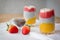 Chia pudding with mango, natural yogurt, chia, wild strawberry  in a glass on a White wooden table. Healthy dessert,  super food