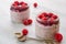 Chia pudding with raspberry in the glass jar on the gray kitchen table decorated with fresh berries and vintage spoons