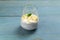 Chia pudding with a sprig of mint in a glass cup on a blue wooden background. Copy space.