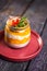 Chia Seed Pudding with Mango and Berries in Glass Jar on Red Plate