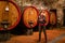 Chianti region, Italy - September 23, 2020: A winery guide in front of old wine barrels in the Chianti region explaining