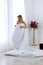 Chic blonde woman in luxury white with red bedroom. Rich expensive interior