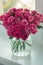 A chic bouquet of small pink roses in a jar on the windowsill. Cute still life