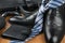 Chic classic black shoes, tie and umbrella, purse and briefcase on the wooden floor