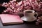 Chic composition, pink table adorned with notebook, flowers, and steaming coffee