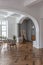 a chic expensive bright interior of a huge living room in a historic mansion with arched arches, columns and white walls decorated