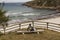 Chica senderista descansa en un banco y disfruta de la vista panoramica de la playa de esteiro en la ruta de los faros