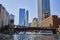 Chicago canal with tour boats under red bridges with blue skyscrapers and office buildings, summer