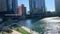 Chicago in the summer including pedestrians, commuters, & tourists enjoying the riverwalk while tour boats, kayaks, el trains