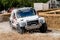 Chichester, West Sussex, UK - June 29, 2014: Landrover rally vehicle slides around corner with hay bails separating onlookers from