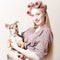 Chick & puppy: beautiful blond pinup girl with red lips & curlers in her hair holding a small cute dog happy smiling