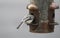 Chickadee eating from an outdoor bird feeder with its head inside feeder