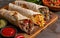 chicken and beef wraps on a board, dark yellow and red, villagecore