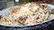 chicken biryani meal in a bowl on table.