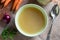 Chicken bone broth in a green soup bowl, top view