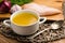 Chicken bouillon in the white bowl on the rustic wooden background.