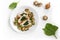 Chicken breast fillet with spinach filling, mushrooms, onion and parsley garnish on a plate, some raw ingredients dispersed on the