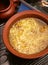 Chicken broth noodle, spaghetti soup with walnuts in pottery bowl.