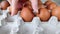 Chicken brown eggs in paper packaging. Close-up. Hand of Caucasian girl lay two eggs in cell of tray. Shooting on bright day,